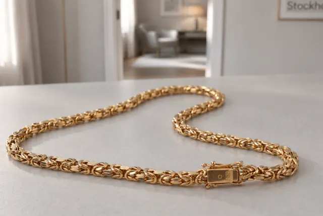 Kejsarlänk halsband i guld som ligger på ett ljust bord