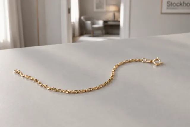 Singapore armband i guld som ligger på ett ljust bord