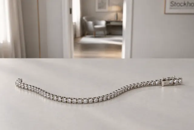 Tennisarmband i guld som ligger på ett ljust bord